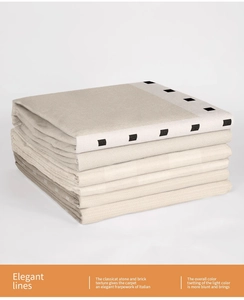 Detail of stacked chenille rugs showing thick woven texture and black geometric patterns