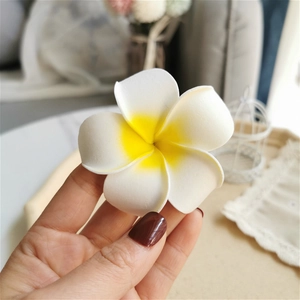 Close-up of realistic white and yellow plumeria flower foam hair clip detail