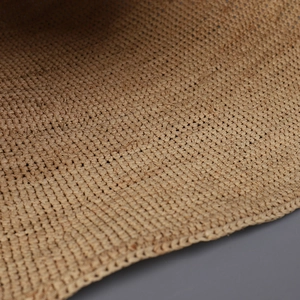 Macro detail of natural raffia fiber weave showing intricate texture and grid pattern