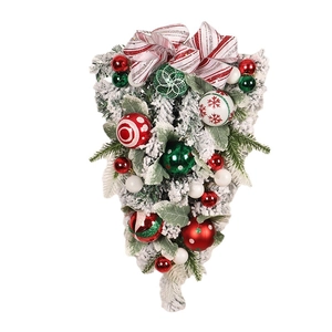 Flocked Christmas teardrop swag with colorful ornaments and a red striped bow decoration
