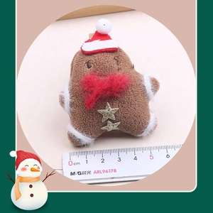Macro detail of plush gingerbread man with Christmas hat and star decorations