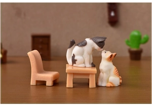 Macro shot of miniature resin cats with table and chair set for micro landscape decor
