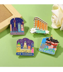 Detailed shot of four colorful enamel Shanghai landmark magnets on a green mat