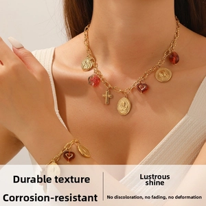 Detailed close-up of vintage gold layered necklace set with coin and cross pendants
