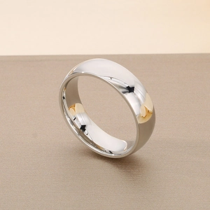 Close-up of polished silver wedding ring with zircon stone on a minimalist background
