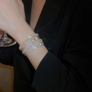 Detail of multi-layer bracelet with pearls and shimmering rhinestones on model wrist