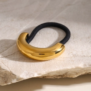 Detail of high-elastic black hair tie with polished gold C-shaped metal ornament