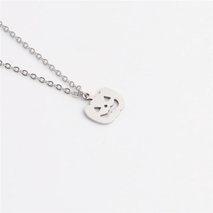 Detail of silver pumpkin lantern pendant with carved face on a stainless steel chain