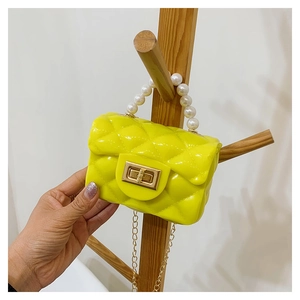 Detail of neon yellow mini jelly bag with diamond lattice pattern and pearl chain