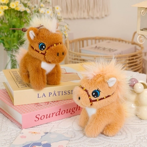 Cute plush pony keychain pendants in brown and orange on a cozy decorative background