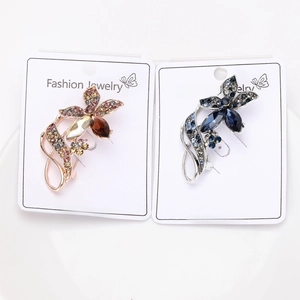 Close-up of luxury rhinestone flower brooches in rose gold and silver finishes on cards