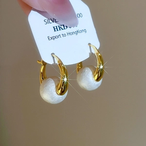 Detail shot of vintage 925 silver gold-plated pearl hoop earrings held on a display card