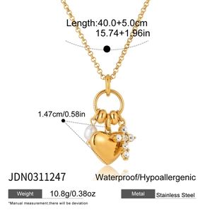 Détail du pendentif cœur en or 18 carats avec croix et perle, montrant les dimensions du bijou
