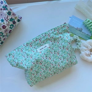Detail of floral cotton makeup bag with simple wish label and mint green pattern