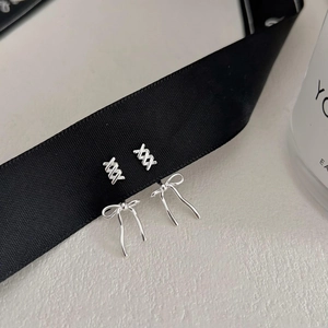 Elegant set of 925 sterling silver bow and cross stud earrings on black ribbon