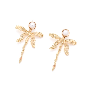 Close-up of golden palm tree earrings featuring white pearl inlay and hollow textures