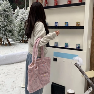 Outdoor view of a large pink plush tote bag with multi-pockets and floral details