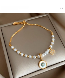 Vue détaillée du bracelet perlé doré ajustable avec pendentif émaillé et fermoir coulissant