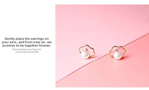 Detailed close-up of cloud-shaped gold earrings with embedded white pearls on a pink background
