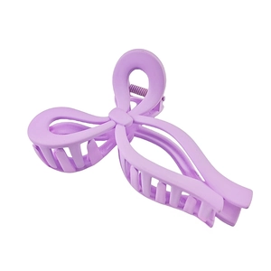 Close-up of matte purple bow-shaped hair claw clip with sturdy spring mechanism