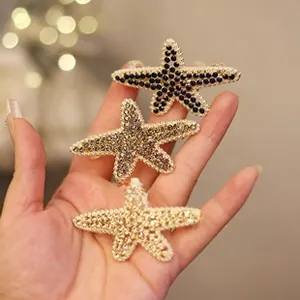 Detail of three starfish hair clips with gold metal base and sparkling rhinestones
