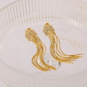 Sparkling crystal tassel drop earrings in 18k gold plating shown on glass bowl