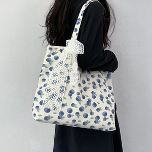 Detailed back view of a canvas tote bag with blueberry print and lace bow decoration