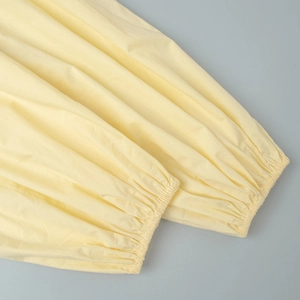 Détail des poignets élastiques à volants sur un ensemble haut sans manches jaune clair