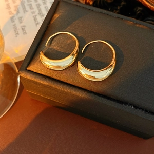 Close-up of gold crescent moon earrings on black jewelry box under warm lighting
