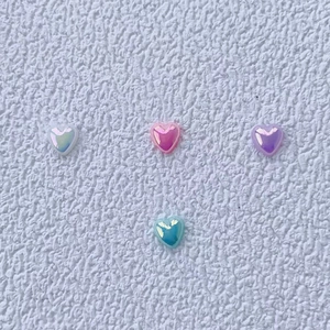 Sparkling aurora resin heart nail art charms in four holographic colors on white background