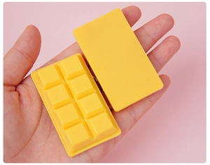 Close-up of bright yellow chocolate-shaped PVC keychain accessory on a pink background