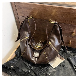 Close-up of vintage dark brown faux leather bag with gold rivets and zipper details