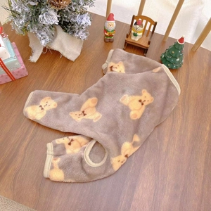 Detail of grey flannel pet onesie with yellow teddy bear patterns on wooden table