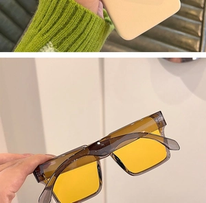 Detail view of modern punk sunglasses featuring transparent grey frames and yellow lenses