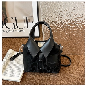 Detailed view of a black shirt-shaped creative tote bag with lace texture and leather trim