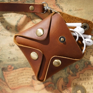 Retro brown genuine leather coin and earphone pouch with clasp and lanyard over vintage map