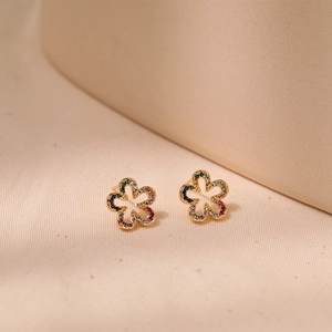 Macro shot of gold floral studs featuring colorful zircon petals and hollow-out design
