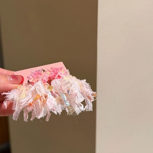 Close-up detail of pink floral earrings with delicate lace tassels and bead accents