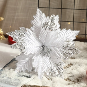 Künstliche weiße Weihnachtablume mit silbernen Pailletten auf verschneitem Grund