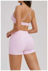 Détail de la brassière rose clair à bretelles croisées et du short taille haute sur mannequin