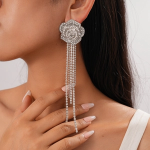 Elegant silver flower drop earrings with long rhinestone tassels worn by a model
