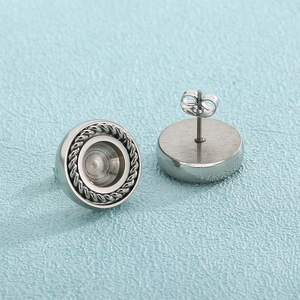 Detailed close-up of silver stainless steel round stud earrings with textured rope edge