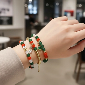 Three-layer Christmas bracelet set with red, green, and gold beads and festive tree charm