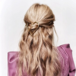 Detailed back view of a golden hollow heart hair clip styled on light blonde hair