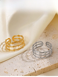 Macro detail of 18K gold plated multi-layer thorn ring on elegant beige silk background