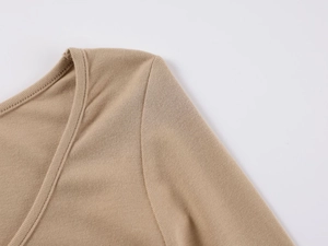 Detail of khaki ribbed cotton bodysuit showing the V-neckline and shoulder stitching