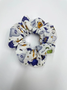 Detail of Halloween hair scrunchie featuring spooky ghost and pumpkin prints on white fabric