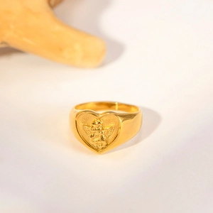 Close-up of golden heart ring featuring a detailed cupid angel relief decoration