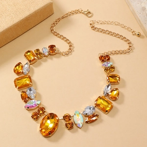 Macro detail of amber and yellow gemstones set in a gold necklace with diverse crystal cuts