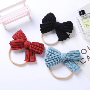 Detail of red, black, and sky blue knitted bow baby headbands on a minimalist background